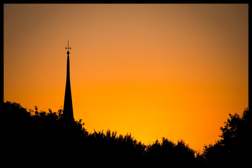 Bei Sonnenuntergang sieht man den Kirchturm von Brokdorf
