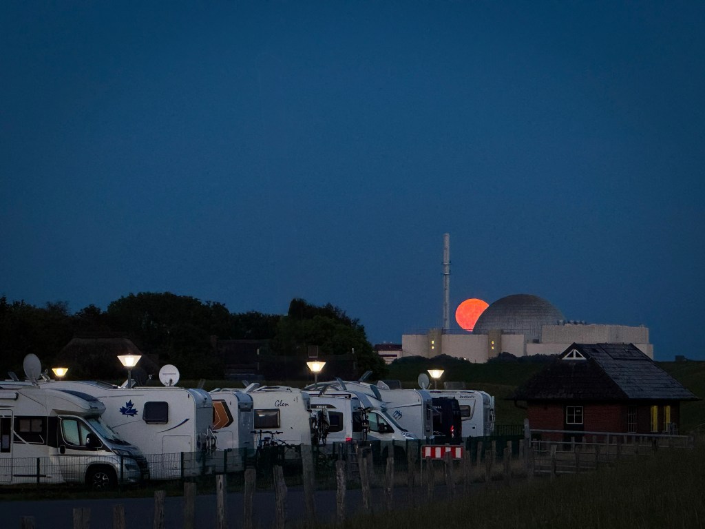 Dieses Bild entstand in Brokdorf kurz vor 22:00 Uhr, es zeigt ein Wohnmobilstellplatz, wo im Hintergrund das AKW Brokdorf zu sehen ist, zwischen dem der rote Vollmond aufgeht
