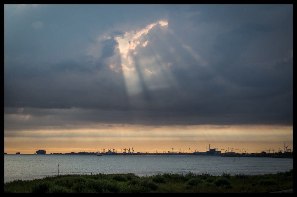 In einer geschlossenen Wolkendecke befindet sich eine Lücke, durch die die Sonnenstrahlen durchbrechen